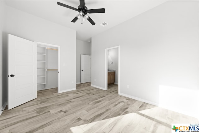 unfurnished bedroom featuring ceiling fan, connected bathroom, a closet, and light wood-type flooring