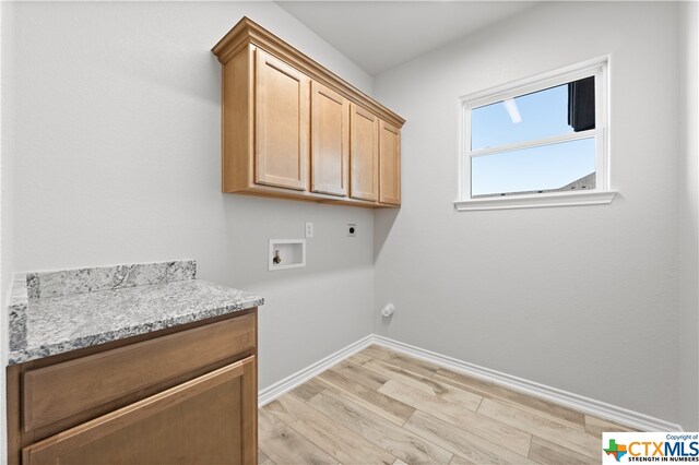 laundry room with light wood-type flooring, cabinets, hookup for a washing machine, and hookup for an electric dryer