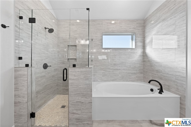 bathroom featuring shower with separate bathtub and lofted ceiling