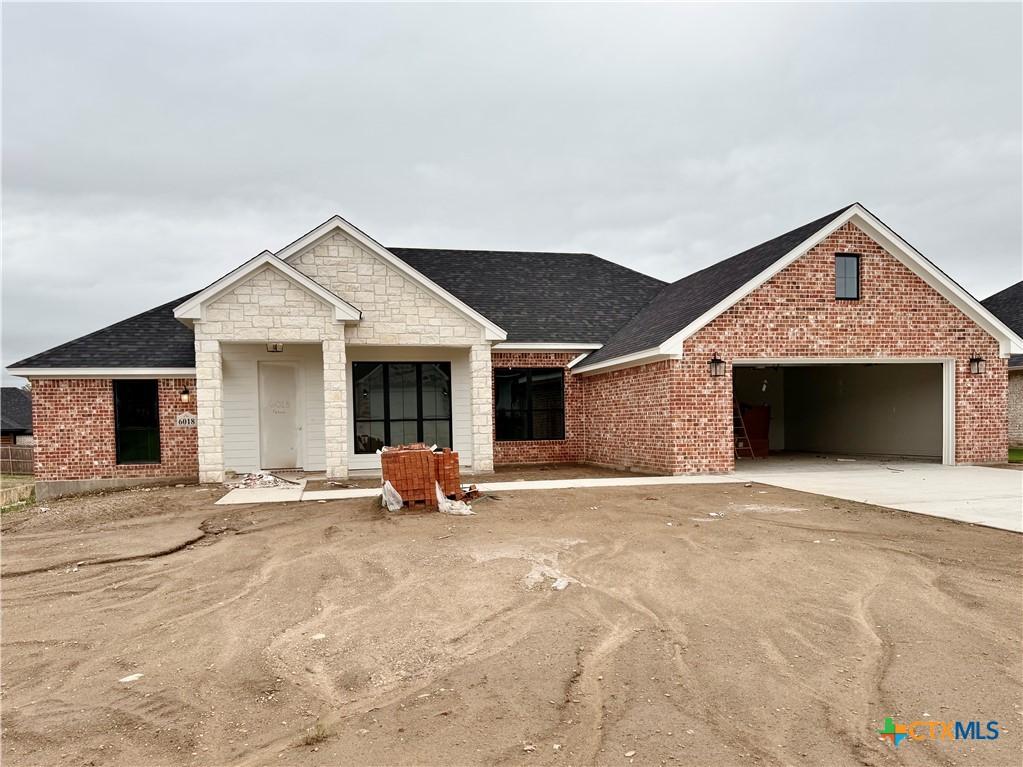 6018 Parma Ln, Temple, TX 76502 - view of front of home featuring concrete driveway, a garage, brick siding, and a shingled roof