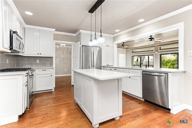 kitchen with tasteful backsplash, light countertops, appliances with stainless steel finishes, ornamental molding, and a sink