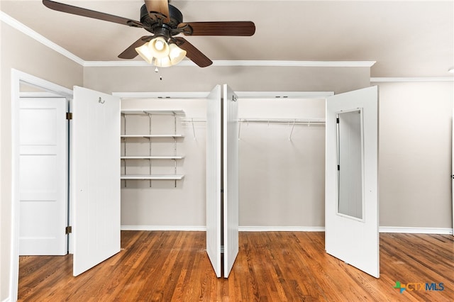 unfurnished bedroom featuring baseboards, ornamental molding, ceiling fan, and wood finished floors