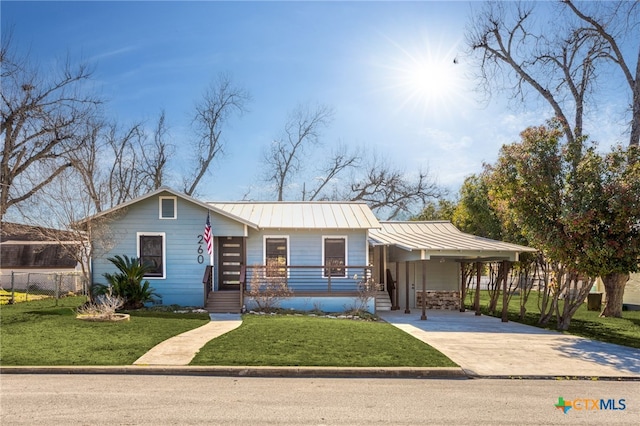 view of front of house with driveway, a front lawn, a standing seam roof, and fence