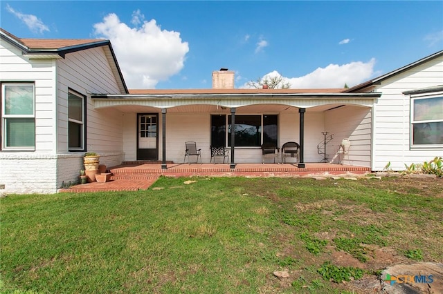 4417 S Pea Ridge Rd, Temple, TX 76502 - rear view of property with a chimney, a yard, brick siding, and a patio area