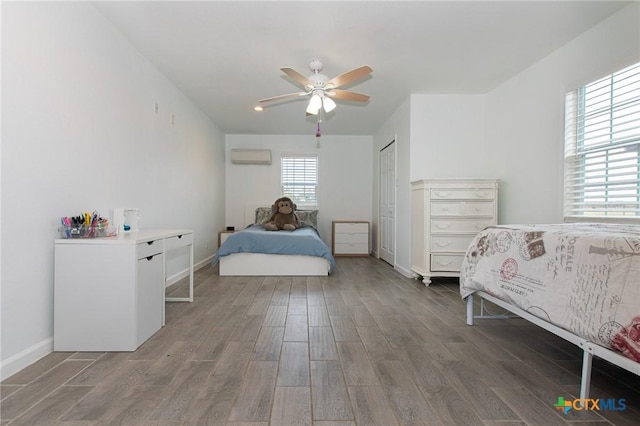 4417 S Pea Ridge Rd, Temple, TX 76502 - bedroom with wood finished floors, an AC wall unit, baseboards, ceiling fan, and a closet