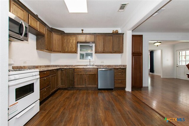 4417 S Pea Ridge Rd, Temple, TX 76502 - kitchen featuring appliances with stainless steel finishes, a sink, crown molding, dark wood finished floors, and light stone countertops