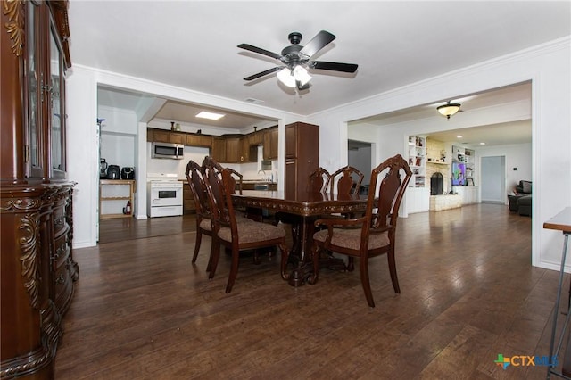4417 S Pea Ridge Rd, Temple, TX 76502 - dining area featuring ceiling fan, dark wood finished floors, ornamental molding, a large fireplace, and baseboards