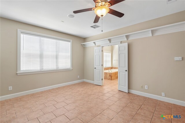 unfurnished room with light tile patterned floors and ceiling fan