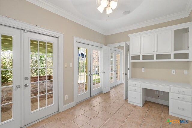 unfurnished office with french doors, built in desk, crown molding, light tile patterned floors, and ceiling fan