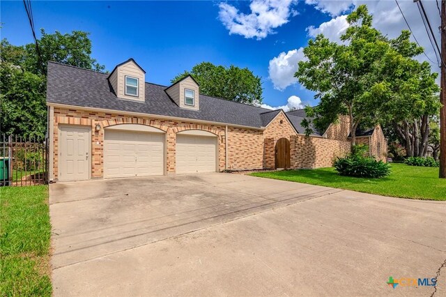 407 E Santa Rosa St, Victoria, TX 77901 - view of front of property featuring brick siding, driveway, an attached garage, and roof with shingles
