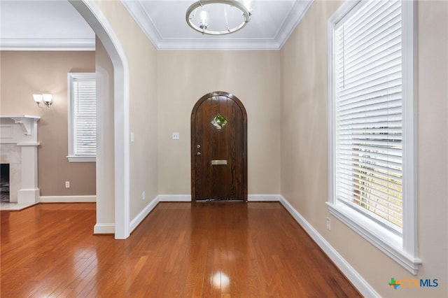 407 E Santa Rosa St, Victoria, TX 77901 - entrance foyer with arched walkways, hardwood / wood-style flooring, crown molding, a premium fireplace, and baseboards