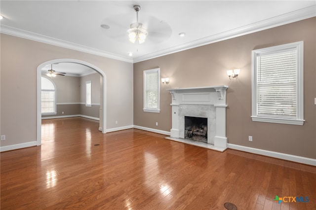 unfurnished living room with ornamental molding, ceiling fan, hardwood / wood-style floors, and a premium fireplace