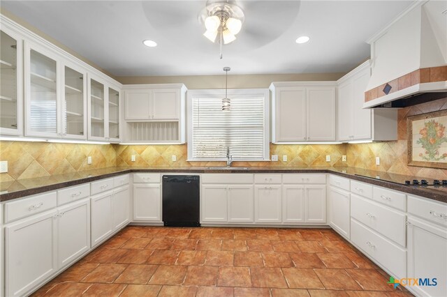 kitchen featuring sink, black appliances, custom range hood, hanging light fixtures, and white cabinets