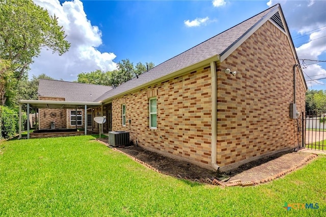 407 E Santa Rosa St, Victoria, TX 77901 - back of house with brick siding, a shingled roof, and central AC unit