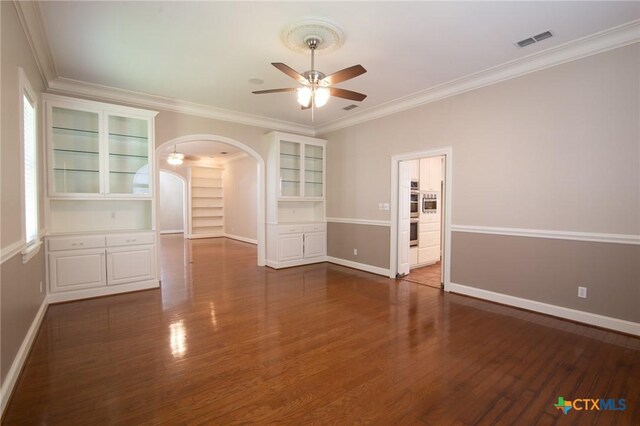 407 E Santa Rosa St, Victoria, TX 77901 - spare room with ceiling fan, arched walkways, dark wood-style floors, baseboards, and ornamental molding