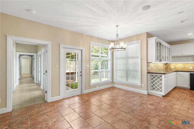 unfurnished dining area featuring a chandelier