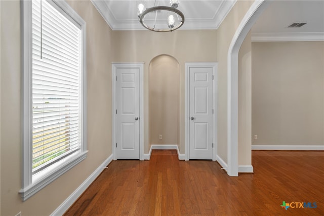 corridor featuring hardwood / wood-style floors, a chandelier, and crown molding