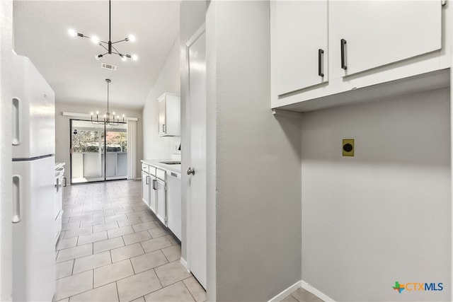 kitchen with white fridge with ice dispenser, white cabinets, a chandelier, decorative light fixtures, and light tile patterned flooring