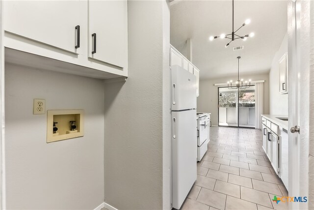 kitchen featuring white cabinets, white appliances, decorative light fixtures, and a notable chandelier