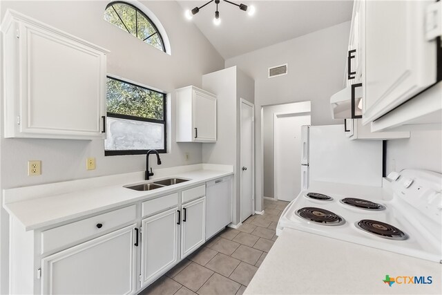 kitchen featuring white appliances, sink, light tile patterned floors, high vaulted ceiling, and white cabinetry