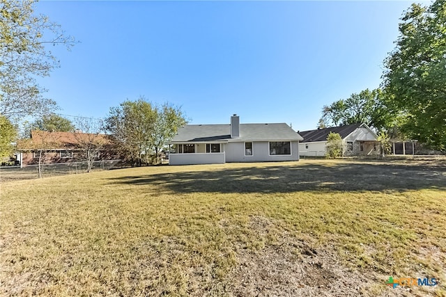 rear view of house featuring a yard