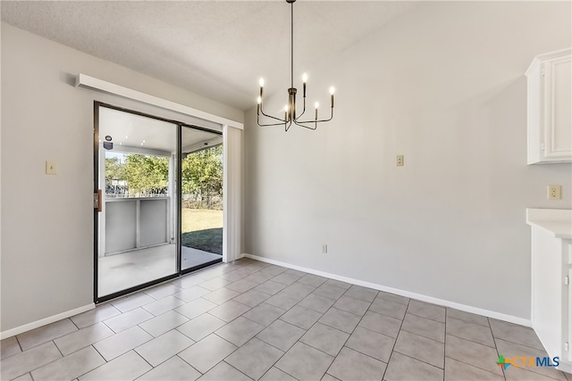 unfurnished dining area with light tile patterned floors, a textured ceiling, and an inviting chandelier