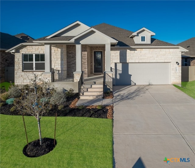 view of front of home featuring a garage, a porch, and a front lawn