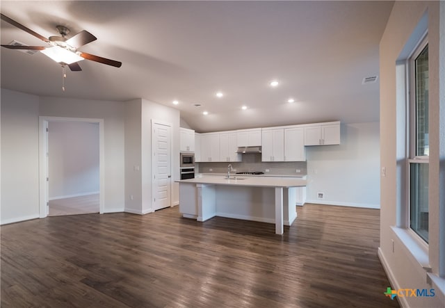 kitchen featuring dark hardwood / wood-style flooring, sink, white cabinets, ceiling fan, and a kitchen island with sink