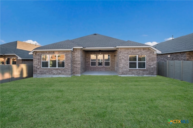 back of house featuring a lawn and a patio