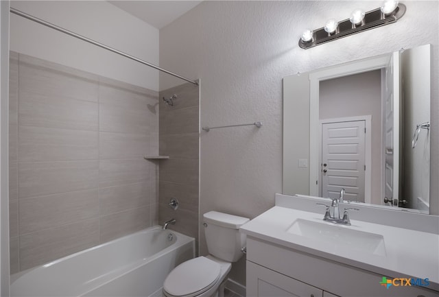 full bathroom featuring vanity, tiled shower / bath combo, and toilet