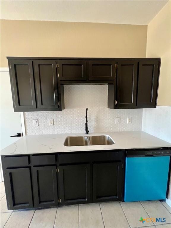 kitchen featuring tasteful backsplash, dishwasher, and a sink