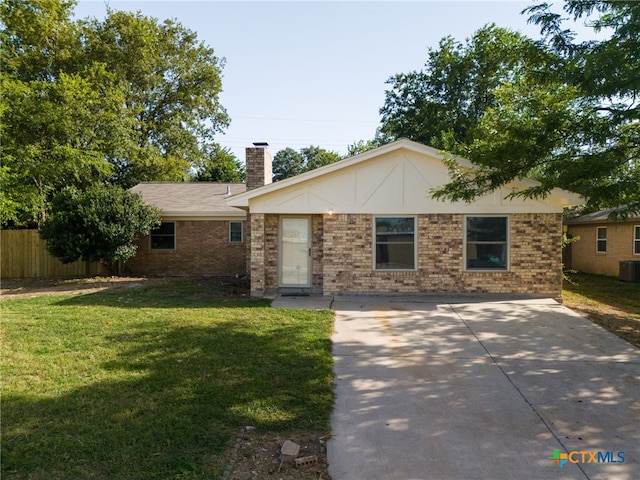 single story home with central AC unit, brick siding, fence, a chimney, and a front yard