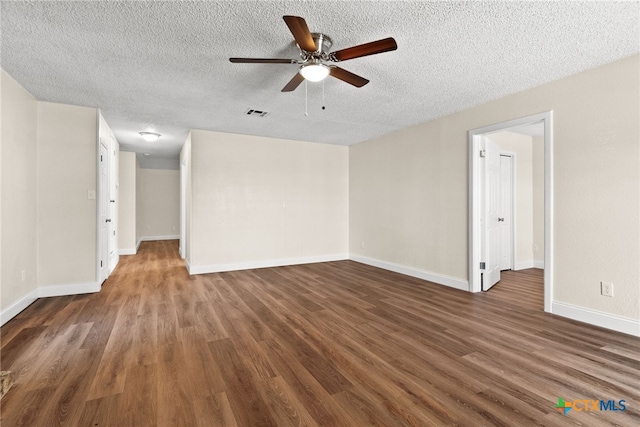 empty room featuring ceiling fan, dark hardwood / wood-style floors, and a textured ceiling