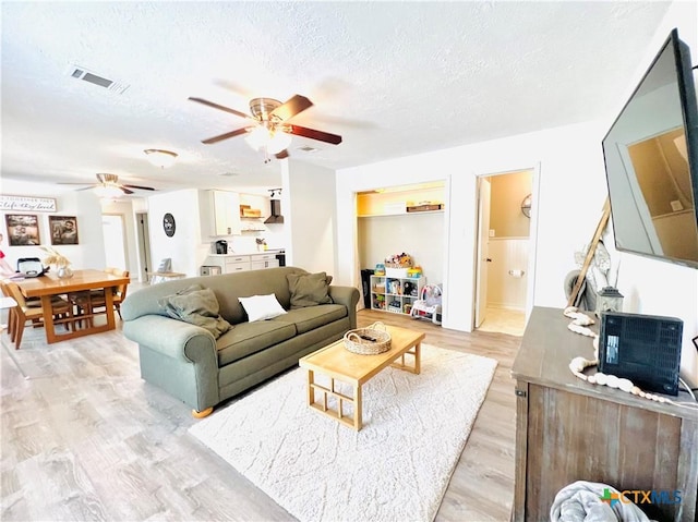 613 E 5th St, Cameron, TX 76520 - living area with a ceiling fan, light wood finished floors, and a textured ceiling