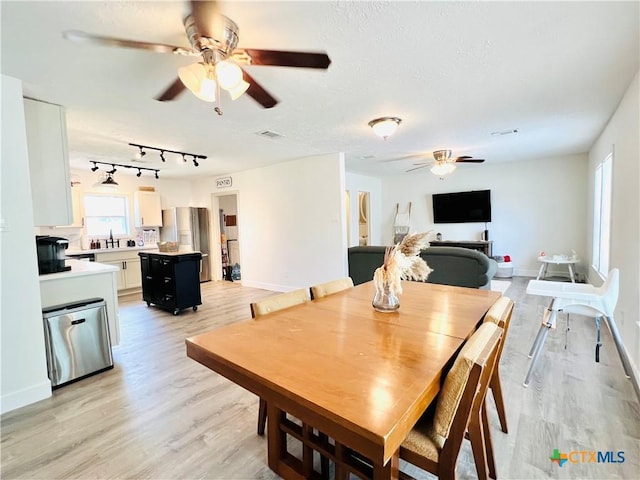 613 E 5th St, Cameron, TX 76520 - dining space featuring ceiling fan, light wood-style flooring, and baseboards