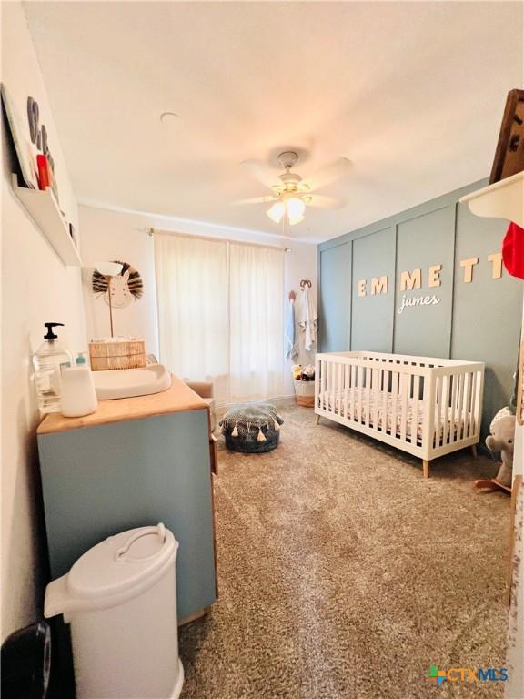 613 E 5th St, Cameron, TX 76520 - bedroom featuring carpet, a nursery area, and a ceiling fan