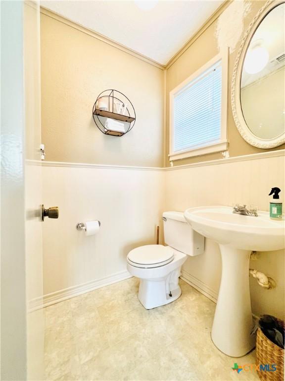 613 E 5th St, Cameron, TX 76520 - bathroom featuring toilet and ornamental molding