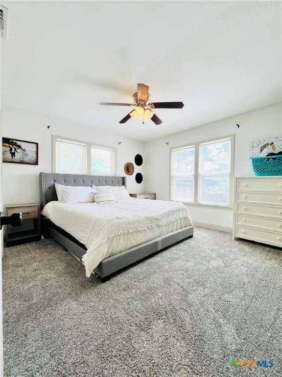 bedroom with multiple windows, ceiling fan, and carpet floors