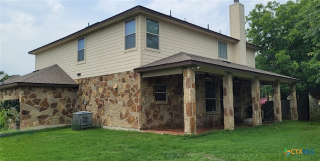 1910 Deerfield Way, Harker Heights, TX 76548 - back of house with stone siding, a chimney, a yard, central AC unit, and a shingled roof