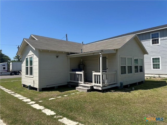 rear view of property with a porch, board and batten siding, and a lawn