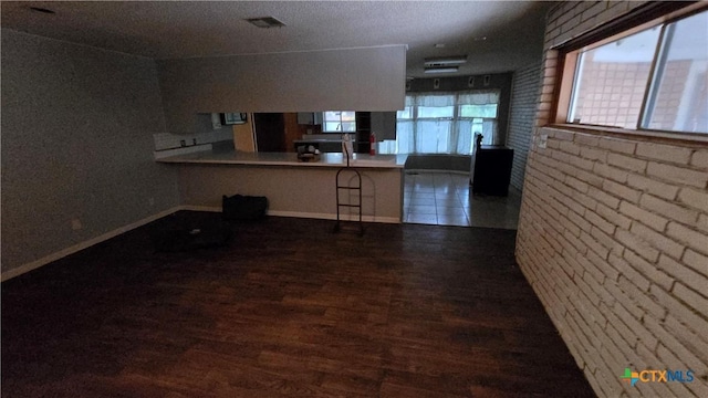 4002 El Capitan Dr, Temple, TX 76502 - kitchen featuring wood finished floors, baseboards, a peninsula, and a breakfast bar area