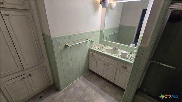4002 El Capitan Dr, Temple, TX 76502 - full bath with vanity, tile walls, a wainscoted wall, and a shower with door