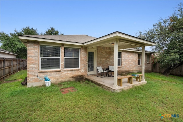 rear view of property with a patio area and a yard