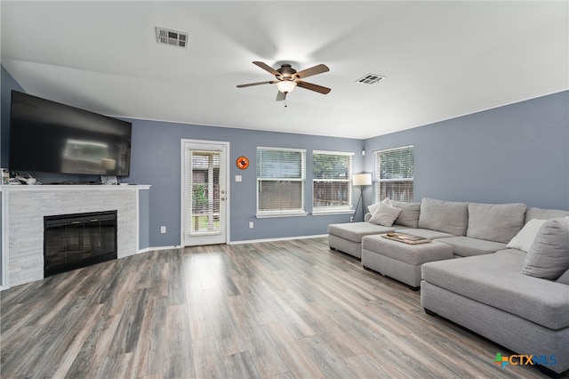 living room featuring a fireplace, hardwood / wood-style floors, and ceiling fan