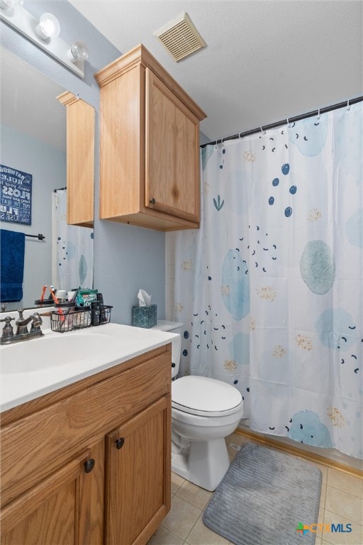 bathroom featuring tile patterned floors, curtained shower, vanity, and toilet