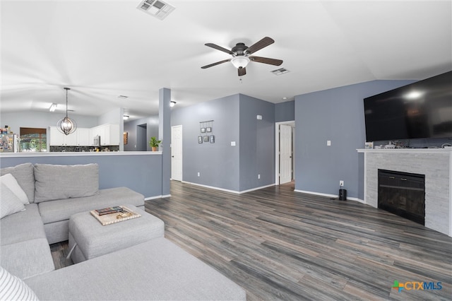 living room with a tile fireplace, dark wood-type flooring, ceiling fan, and lofted ceiling