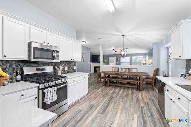 kitchen with tasteful backsplash, white cabinetry, and appliances with stainless steel finishes