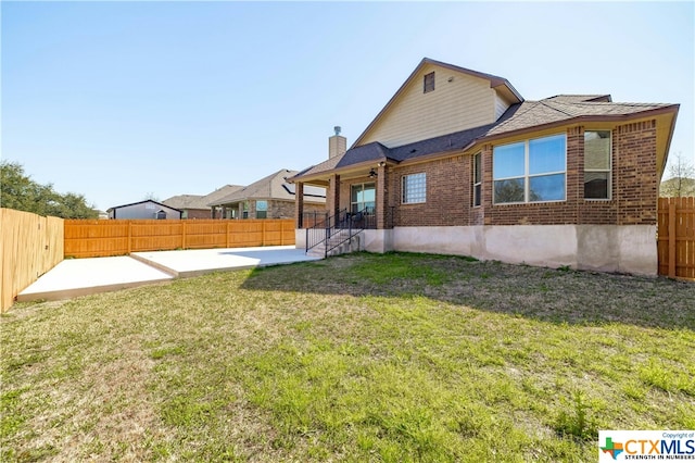 back of house with a lawn and a patio