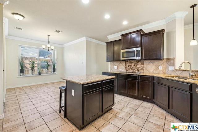 kitchen featuring an inviting chandelier, pendant lighting, sink, and crown molding