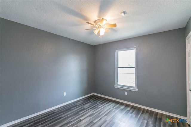 empty room with dark hardwood / wood-style flooring, a textured ceiling, and ceiling fan